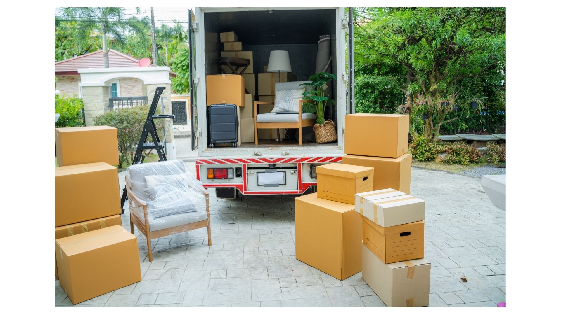 Family movers College Station TX, moving truck loaded with household boxes and furniture outside a home during a family move