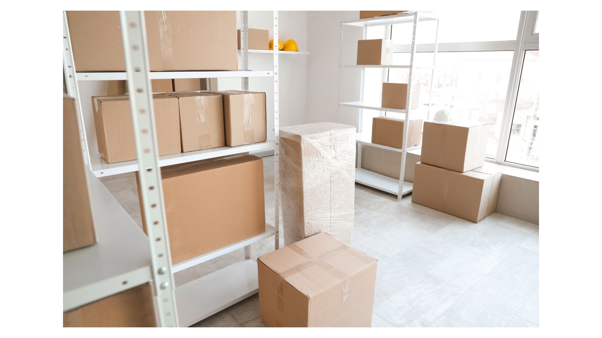 Storage units College Station TX — boxes and wrapped furniture organized on shelving in a clean storage facility
